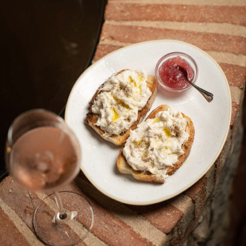 Creamy whipped codfish crostini with onion jam, paired with a glass of rosé at Oratio Wine Bar & Library in Florence.