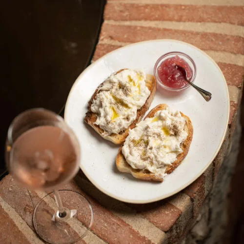 Creamy whipped codfish crostini with onion jam, paired with a glass of rosé at Oratio Wine Bar & Library in Florence.