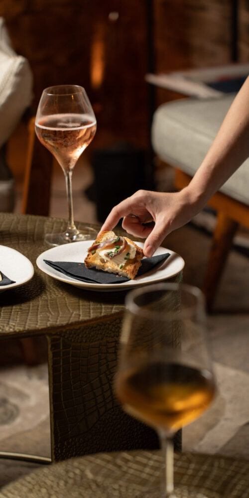 Elegant wine and food pairing at Oratio Wine Bar & Library, featuring a gourmet appetizer and a glass of sparkling rosé.